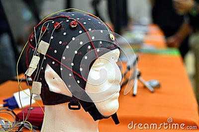 The electroencephalogram EEG head cap with flat metal discs electrodes attached to a white plastic modelâ€™s head Stock Photo